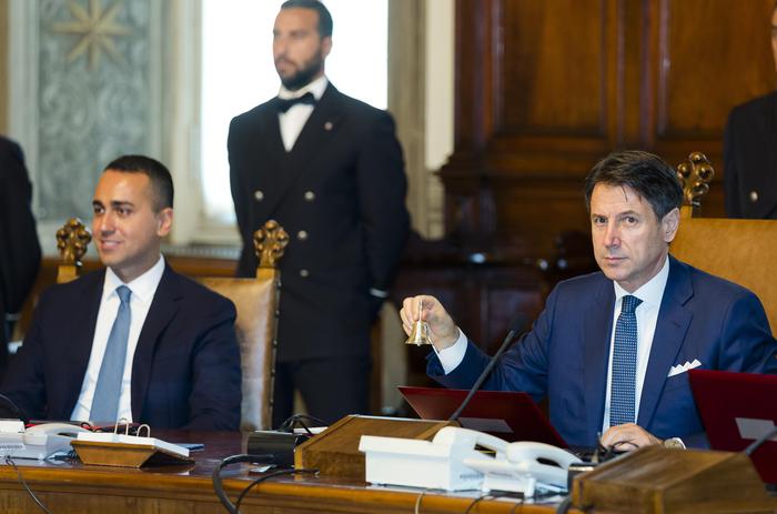 Italy's Prime Minister Giuseppe Conte, right, flanked by Foreign Minister Giuseppe Di Maio, poses with the bell that traditionally opens the meeting of the cabinet as he starts the first cabinet meeting of his new government at Chigi Palace in Rome, Thursday, Sept. 5, 2019. Italian Premier Giuseppe Conte forged a new coalition government Wednesday that teams up the populist 5-Star Movement and center-left Democrats in an unusual alliance of rivals to banish for now the specter of early election that likely could have seen the triumph of Italy's fast-rising right-wing forces. (ANSA/AP Photo/Domenico Stinellis) [CopyrightNotice: Associated Press]